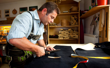 Engelbert Aigner senior schneidet das Hirschlder für eine Lederhose zu