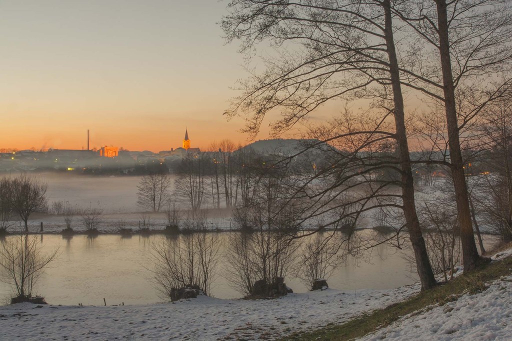 Sonnenuntergang über Teisendorf im Winter mit der Kirche St. Andreas und dem Pfarrer-Weiher im Vordergrund (c) roha-fotothek Fürmann